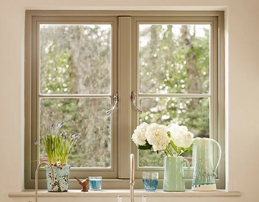 Green casement window above a kitchen sink