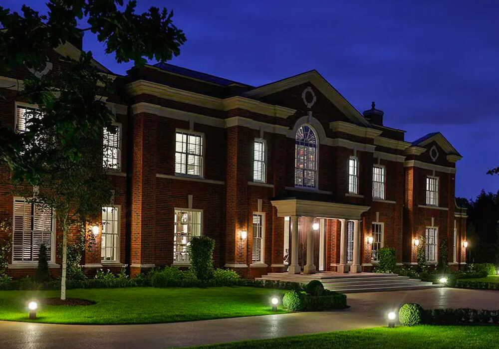 Big house at night with all the lights on through the sliding sash windows