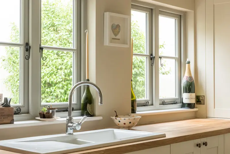 Grey timber windows in kitchen with monkey tail handles